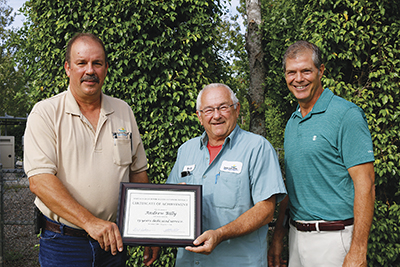 Andy Billy, center, receives award from Stephen Hinkle, Board President, left, and Manager of Operations Mike Dillon on right.
